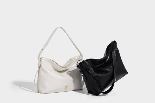 Large slouchy hobo shoulder bag in glossy crinkle leather-look finish with gold-tone emblem hardware and adjustable strap