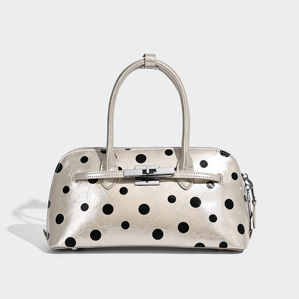 Structured polka-dot Boston bag with glossy crinkled finish, dual top handles, silver-tone turn-lock clasp, and detachable