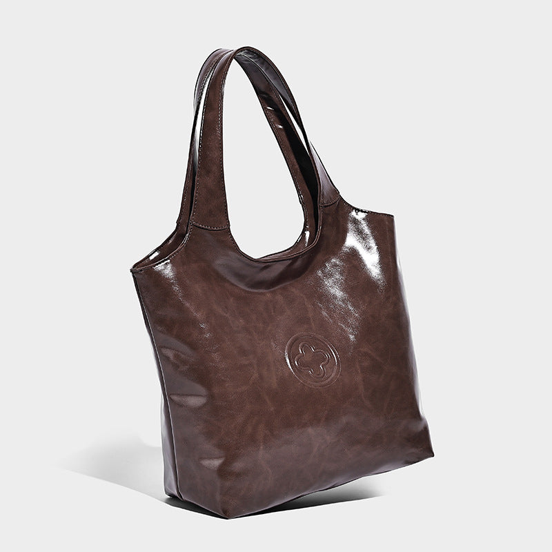 Glossy oil-wax leather-look open-top tote shoulder bag with embossed circular logo and long double straps, front view