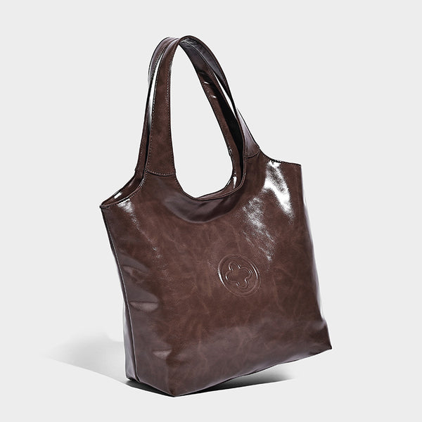 Glossy oil-wax leather-look open-top tote shoulder bag with embossed circular logo and long double straps, front view