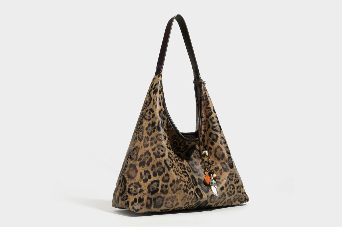 Weich fallende Hobo-Tote-Bag mit Leopardenmuster in Beige und Braun, dunkelbraunem Riemen in Lederoptik und herabhängenden Perlenanhänger-Beschlägen
