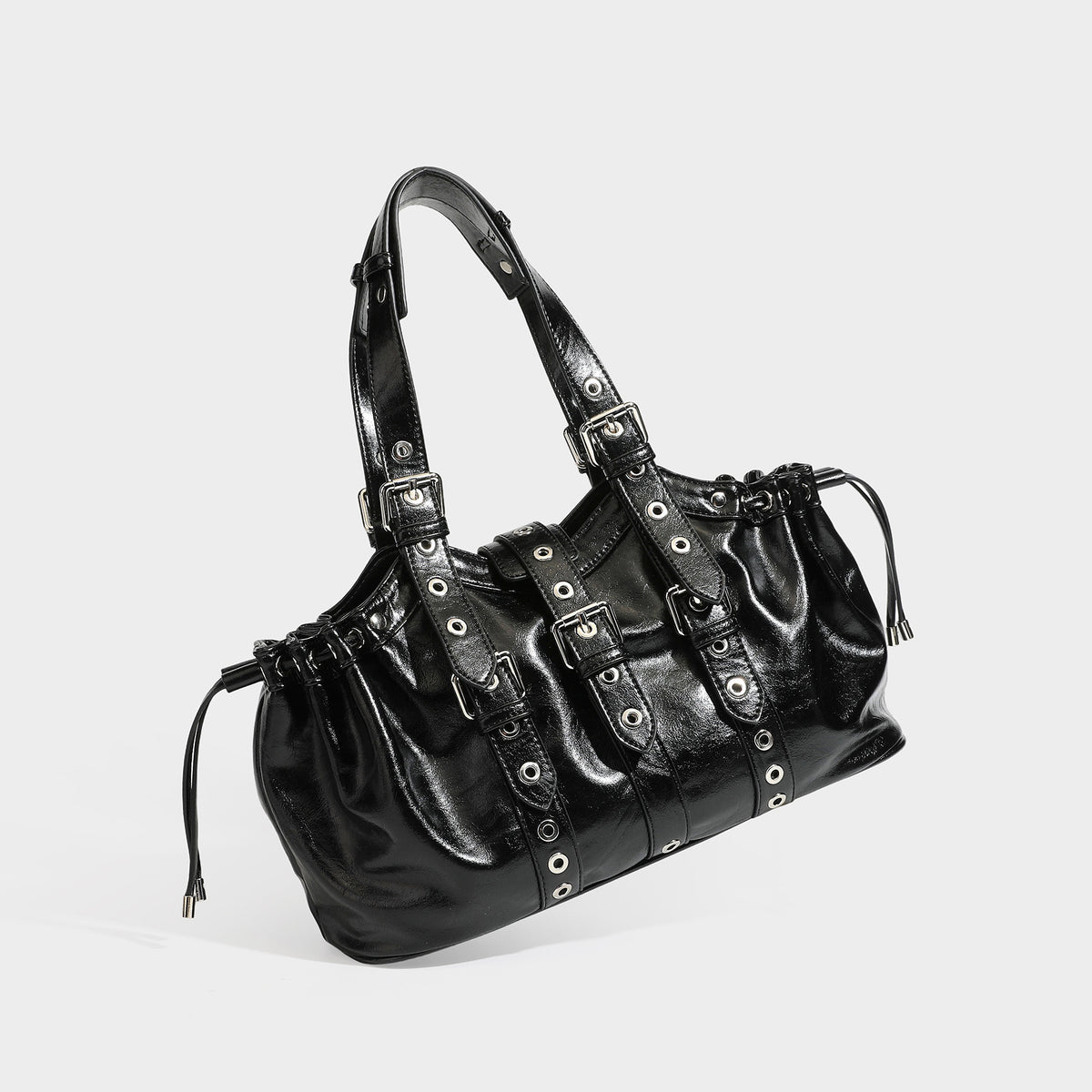Large black glossy leather-look tote bag with silver buckle straps, eyelet grommet panels, drawstring side gathers, and