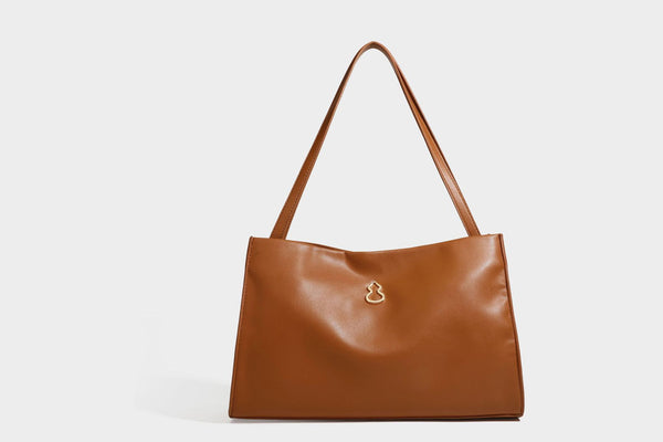 Structured rectangular shoulder tote bag with smooth leather-look finish, long double straps, and gold-tone gourd emblem on