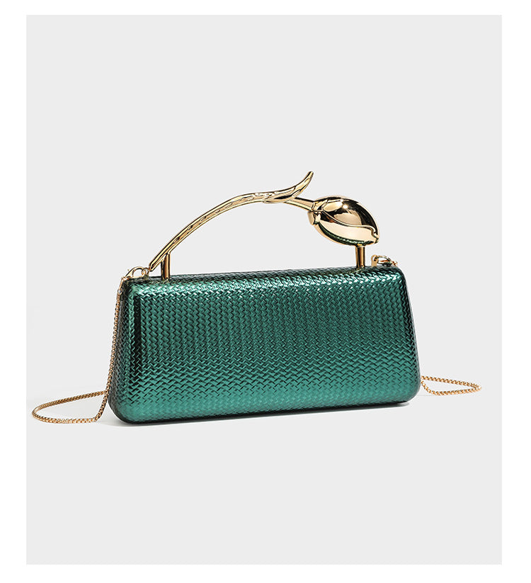 Structured rectangular metallic woven clutch bag with sculptural gold-tone leaf top handle and detachable chain strap, detail