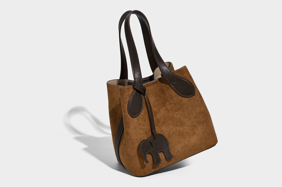Kleine, strukturierte Tote-Handtasche in Wildlederoptik mit Elefantenanhänger, zwei oberen Tragegriffen und abnehmbarem Crossbody-Riemen, Detailansicht