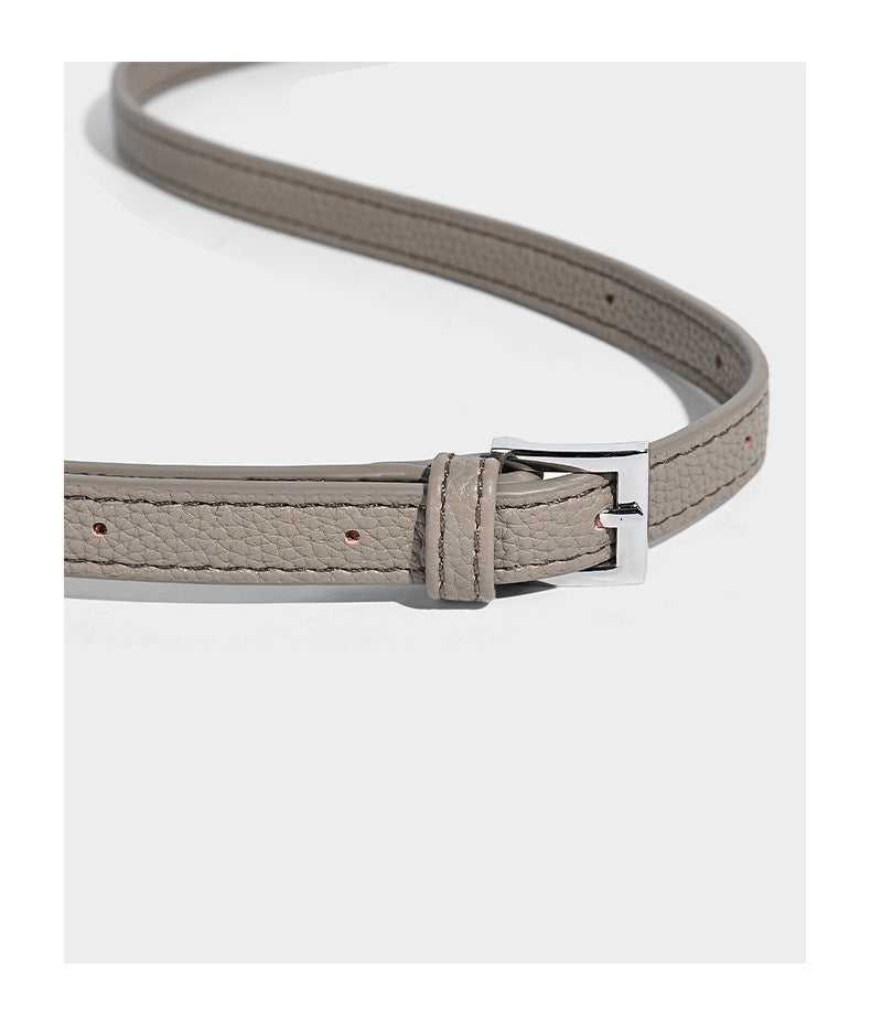 Structured pebbled leather-look tote bag with detachable scarf tie, dual top handles, and adjustable crossbody strap, detail