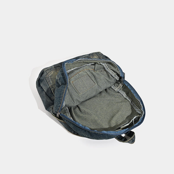 Vintage wash dark indigo denim backpack with jacket collar detail, snap buttons, patch pockets, and leather-look label