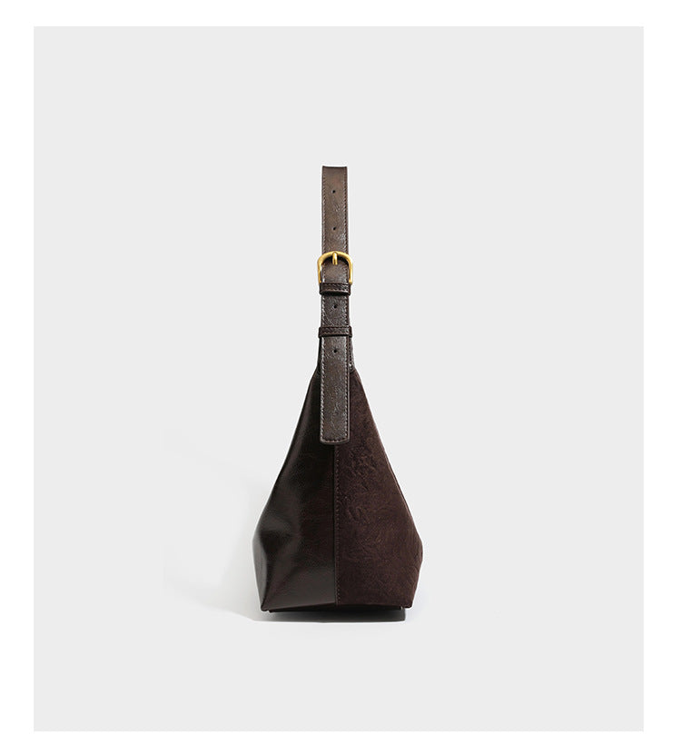 Dunkelbraune, lässig fallende Hobo-Schultertasche mit velourslederähnlich strukturierter Oberfläche, glatter lederähnlicher Paspelierung und Details in Antikgoldoptik, Detailansicht