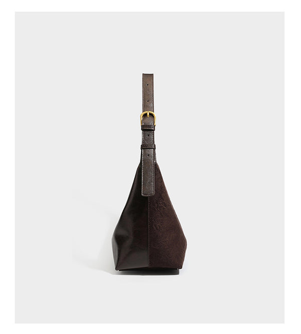 Dunkelbraune, lässig fallende Hobo-Schultertasche mit velourslederähnlich strukturierter Oberfläche, glatter lederähnlicher Paspelierung und Details in Antikgoldoptik, Detailansicht