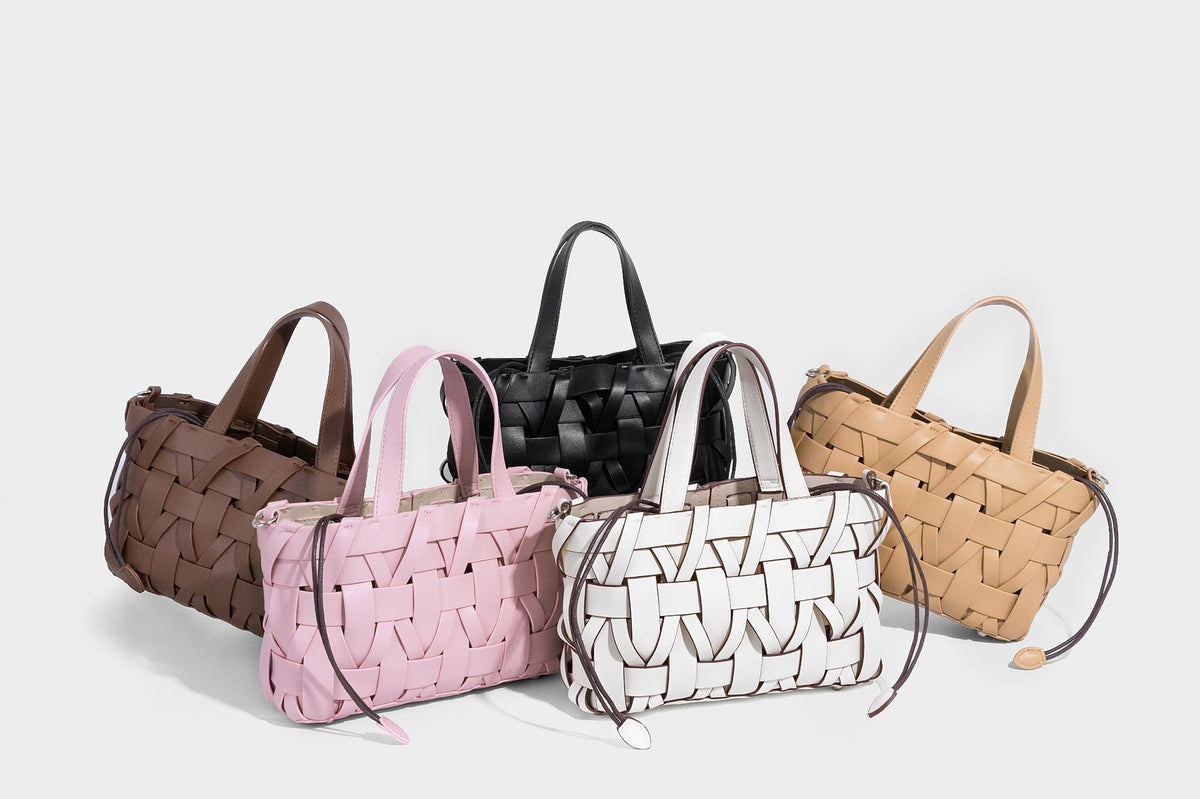 Structured woven basket tote handbag with contrasting dark trim, double top handles, detachable shoulder strap, and