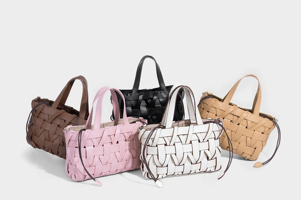 Structured woven basket tote handbag with contrasting dark trim, double top handles, detachable shoulder strap, and
