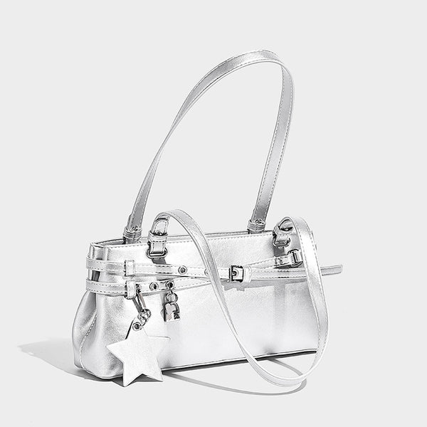 Structured glossy leather-look shoulder bag with wraparound belt straps, silver-tone hardware, and dangling star charm