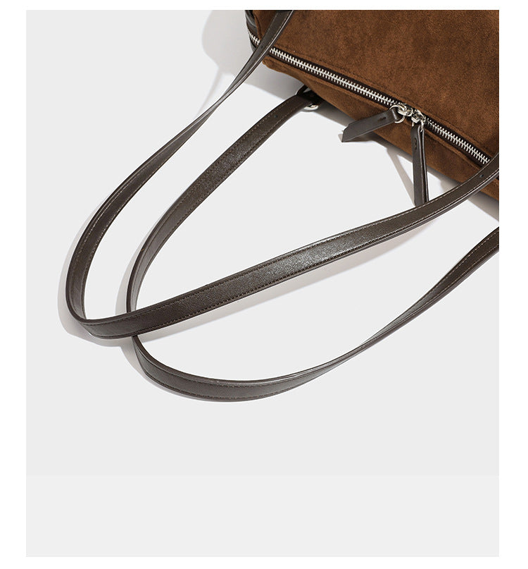 Large brown suede-finish barrel shoulder bag with dark leather-look trim, silver-tone zippers, dual top handles, and long