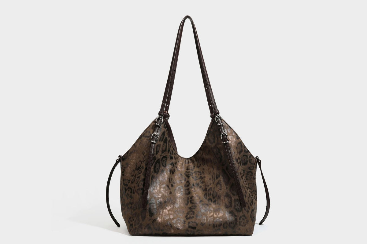 Slouchy leopard-print shoulder tote bag in tan and brown with long double straps, side tie straps, and dangling charm, detail