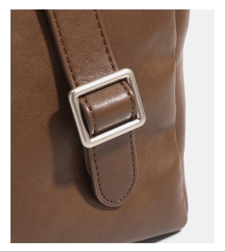 Structured flap backpack handbag in smooth leather-look finish with buckle front pocket, top handle, and silver-tone