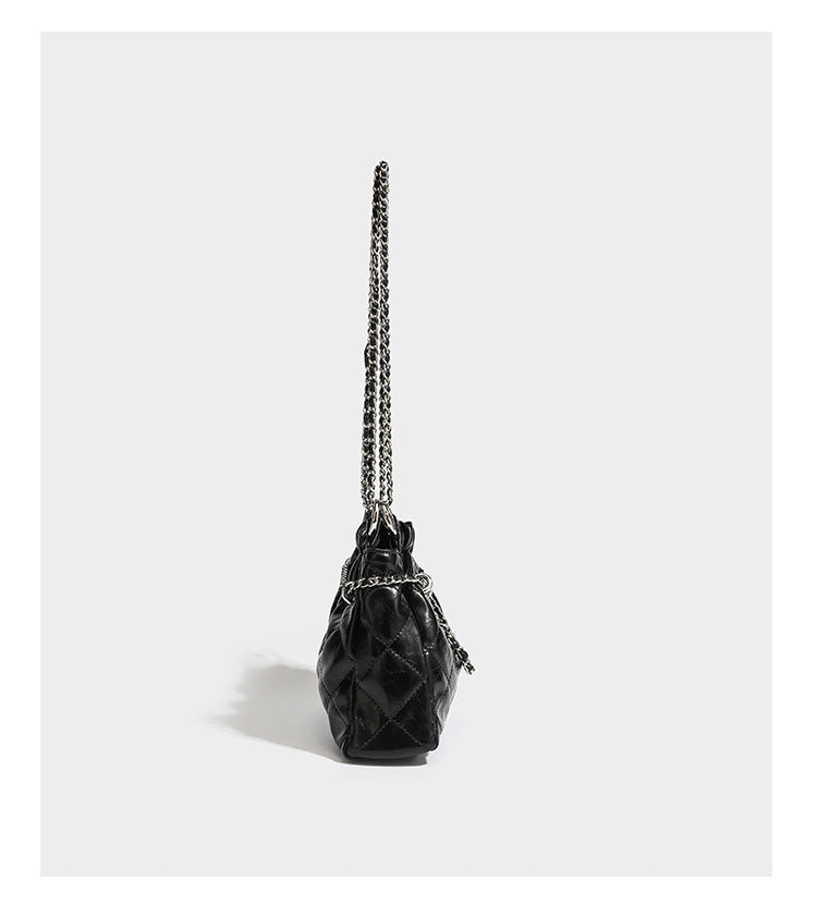 Glossy diamond-quilted drawstring bucket bag with silver chain shoulder strap and medallion charm, detail view 11
