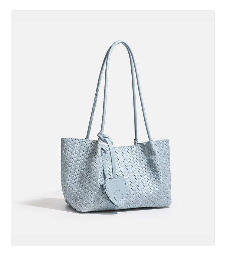 Woven leather-look tote bag in yellow with long shoulder straps, heart-shaped hanging charm, and removable inner zip pouch
