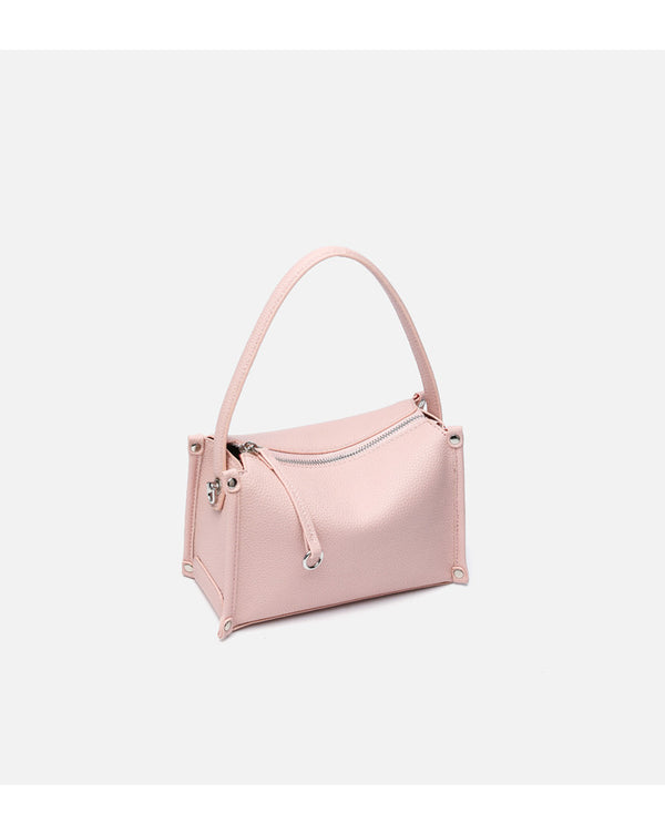 Small structured pebbled-finish convertible bag with silver corner studs, zip top, and detachable shoulder strap, detail view