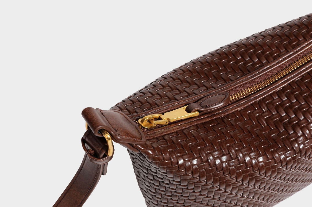 Small glossy basket-weave hobo shoulder bag in brown with knotted top handle, flap accent pocket, and gold-tone hardware