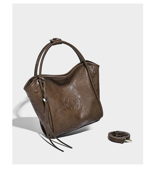 Glänzende Tote-Bag in geknautschter Lederoptik mit geprägtem rundem Emblem, Quastenschnürung, zwei Henkeln und abnehmbarem