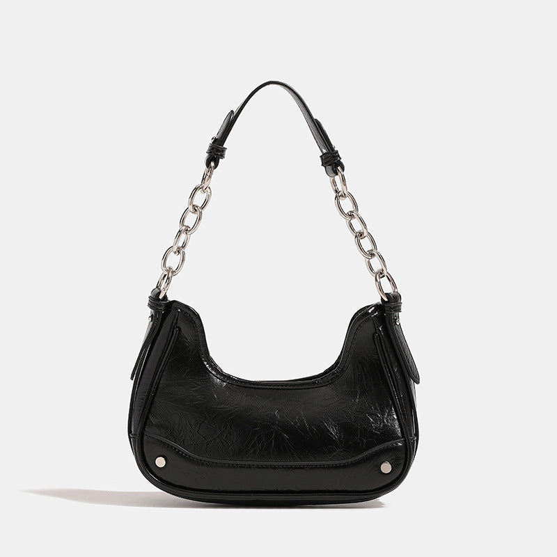 Compact crescent hobo shoulder bag in glossy burgundy leather-look finish with silver chain strap, red and green bead tassel