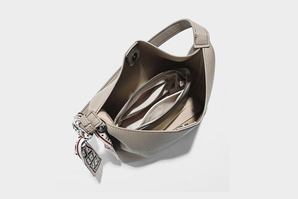 Soft slouchy hobo shoulder bag in pebbled matte finish with slim strap, silver-tone ring hardware, and knotted printed scarf