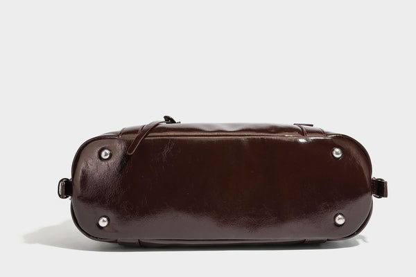 Strukturierte Schultertasche in glänzender Lederoptik mit abgerundetem Korpus, silberfarbenen Beschlägen, Reißverschlussfach auf der Vorderseite und Leopardenmuster