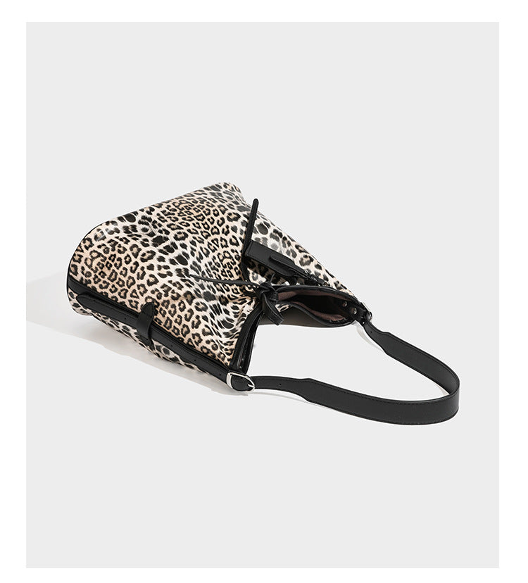 Slouchy leopard print shoulder hobo bag with black leather-look trim, tie-top closure, and single long strap, detail view 10