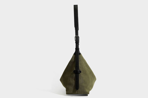 Slouchy olive green canvas hobo shoulder bag with black leather-look trim, zip-top closure, and adjustable strap, detail view