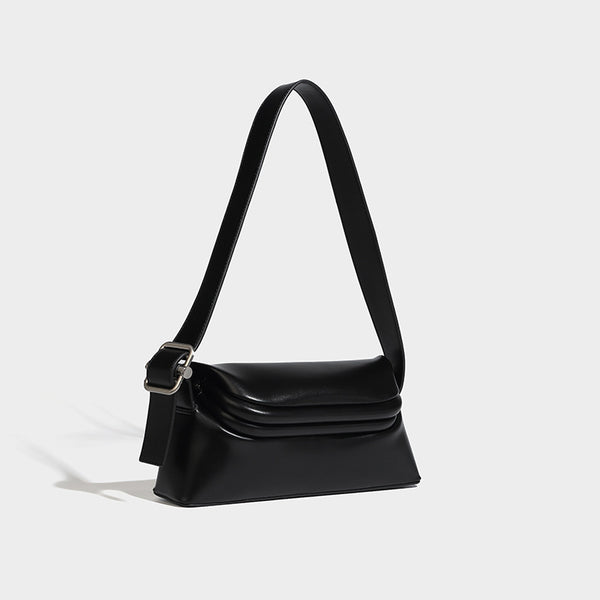 Compact structured baguette shoulder bag with smooth leather-look finish, zip top, and adjustable silver-buckle strap, detail
