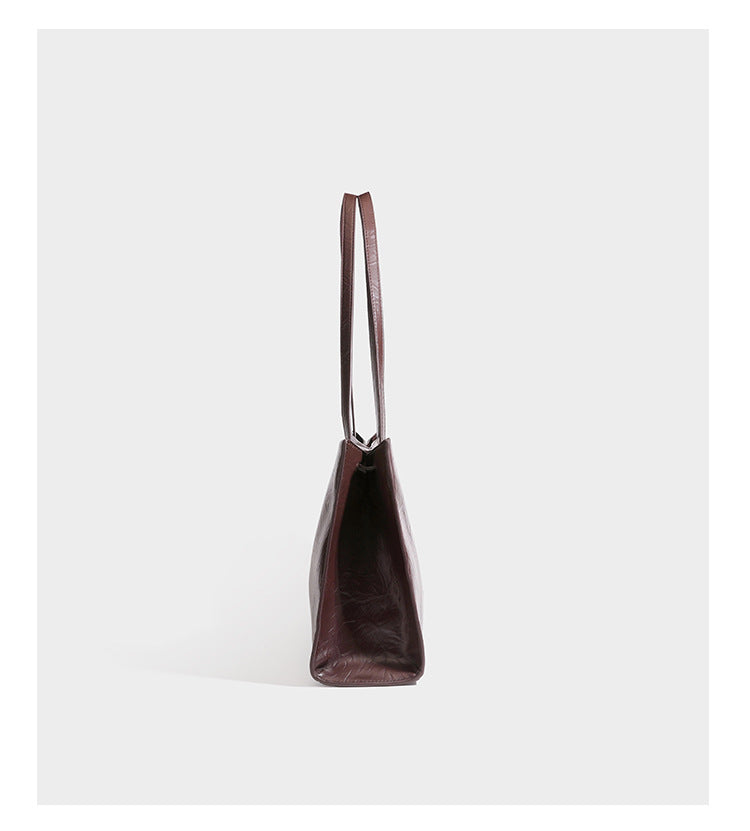 Strukturierte, rechteckige Tote-Schultertasche mit glänzender, geknautschter Lederoptik, langen Doppelriemen und goldfarbenem Emblem