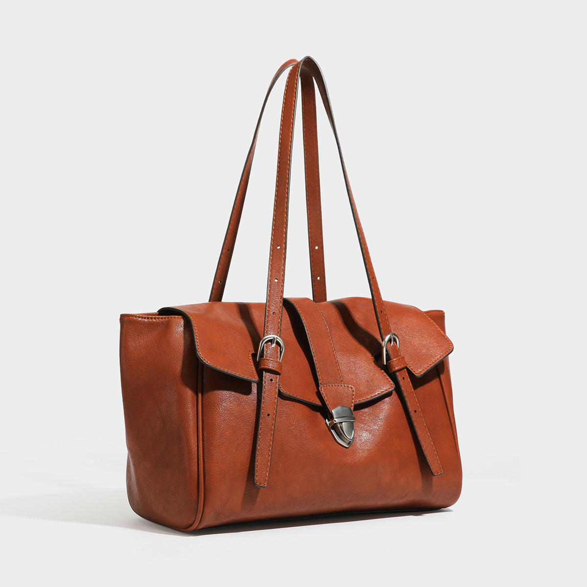 Large structured vintage-style tote bag with flap-front turn-lock closure, twin buckle straps, and double shoulder handles