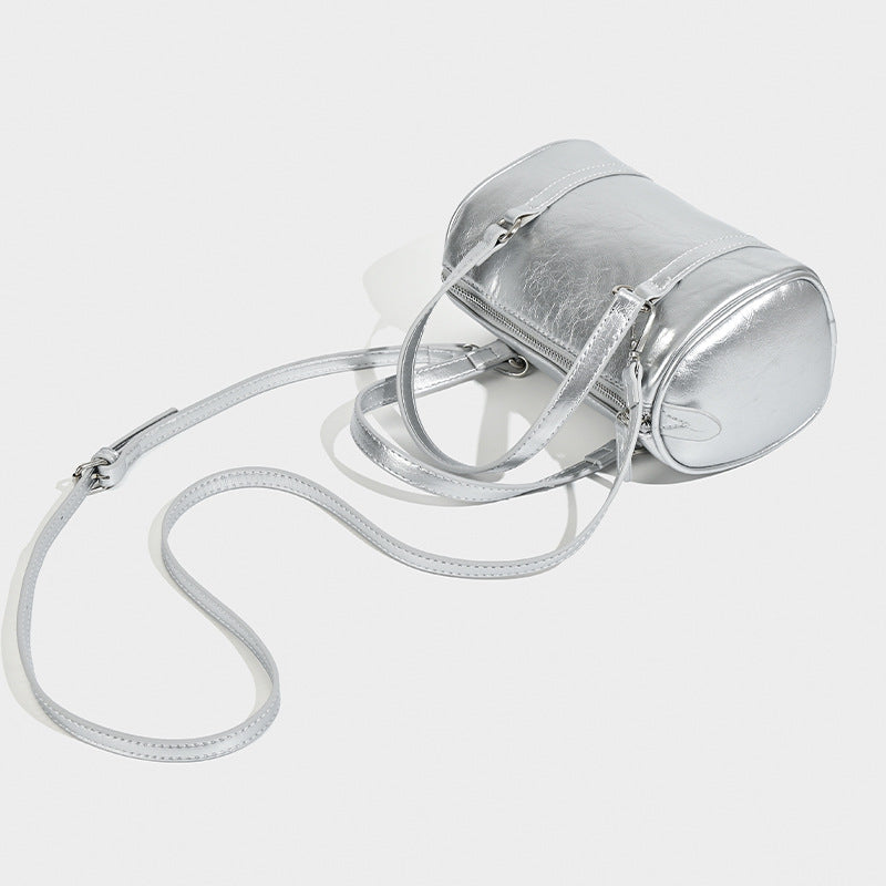 Mini silver barrel bag with crinkled leather-look finish, top handles, and silver-tone hardware, detail view 3