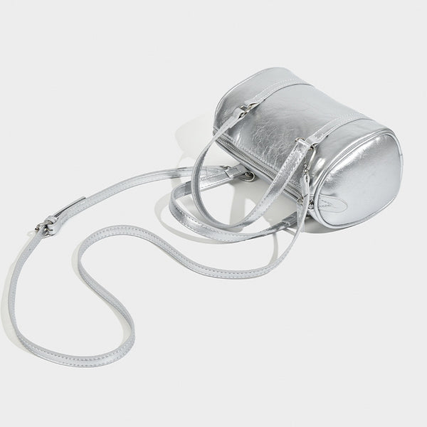 Mini silver barrel bag with crinkled leather-look finish, top handles, and silver-tone hardware, detail view 3