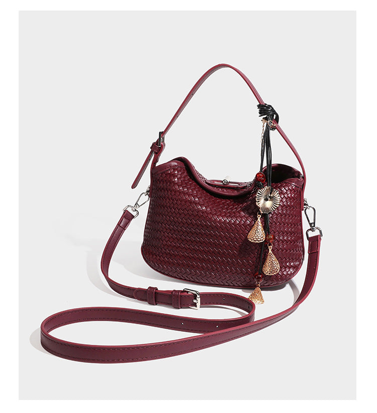 Small woven-look leather-look flap shoulder hobo bag in burgundy with silver-tone hardware and decorative tassel charm