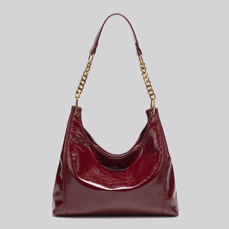 Glänzende Hobo-Schultertasche in Lederoptik mit Kettenriemen und Riemen aus Leder in Goldoptik, in tiefem Burgunderrot, Vorderansicht