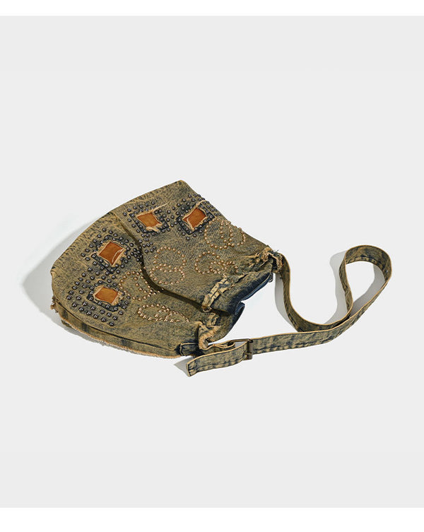 Large distressed denim hobo shoulder bag with mixed-metal rivet detailing and tan leather-look corner trim, detail view 8
