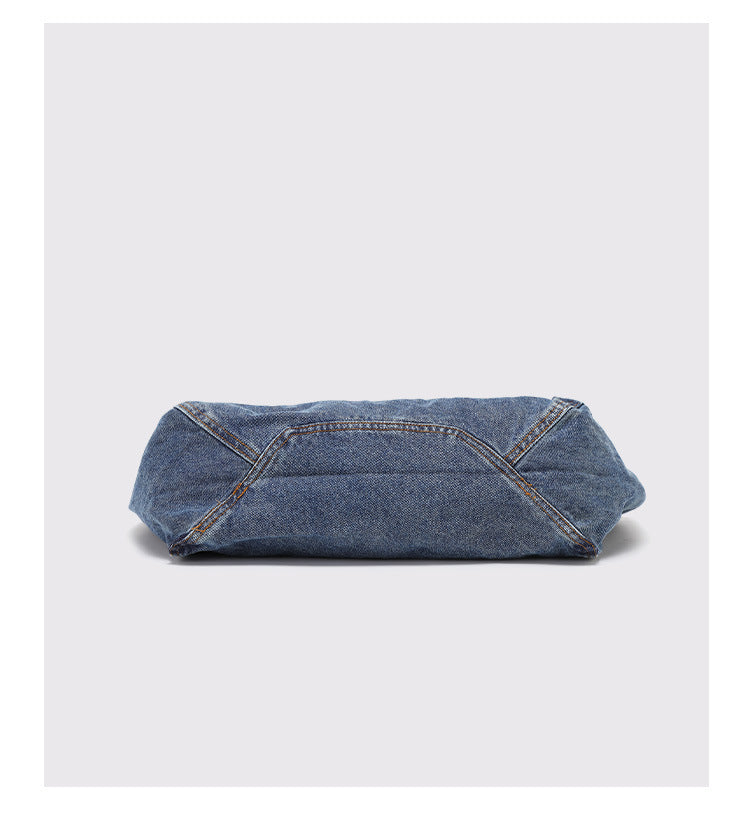 Große Tote-Bag aus verwaschenem blauem Denim mit handschriftlich wirkendem Grafikprint, kontrastierenden orangefarbenen Nähten und langem Stoff-Schulterriemen