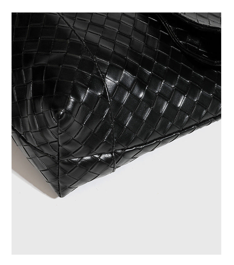 Große schwarze Schultertasche in gewebter Lederoptik mit geflochtenem Tragegriff, Überschlagverschluss und verstellbarem Crossbody-Riemen, Detailansicht