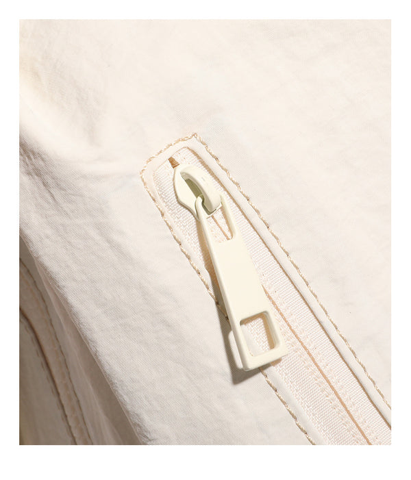 Lässige Crossbody-Tasche aus weichem Stoff mit geflochtenem Tragegriff aus Kordel, diagonalem Reißverschlussfach auf der Vorderseite und silberfarbenen Beschlägen, Detailansicht
