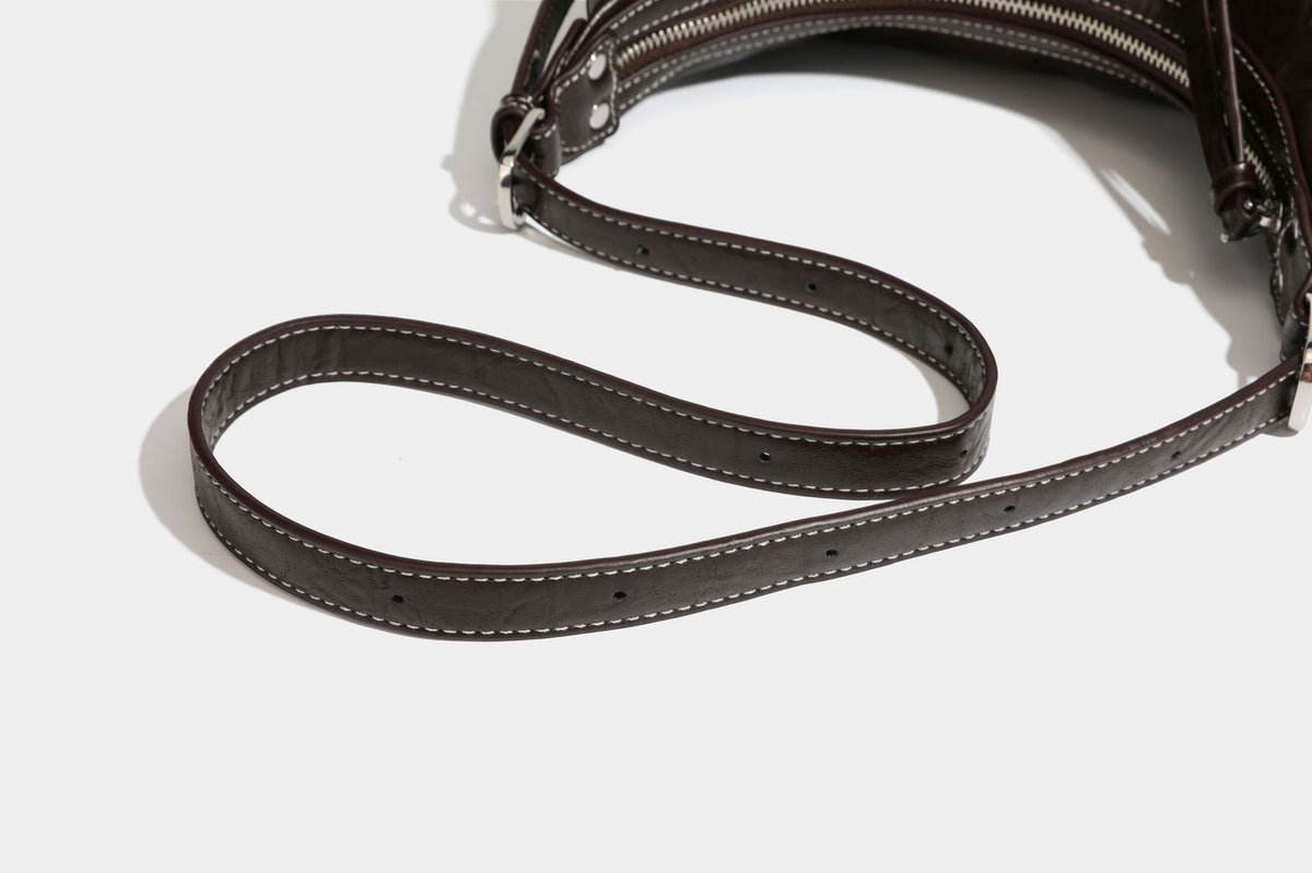 Slouchy hobo shoulder bag in glossy crinkled leather-look finish with zip-top closure and silver-tone ring hardware, detail