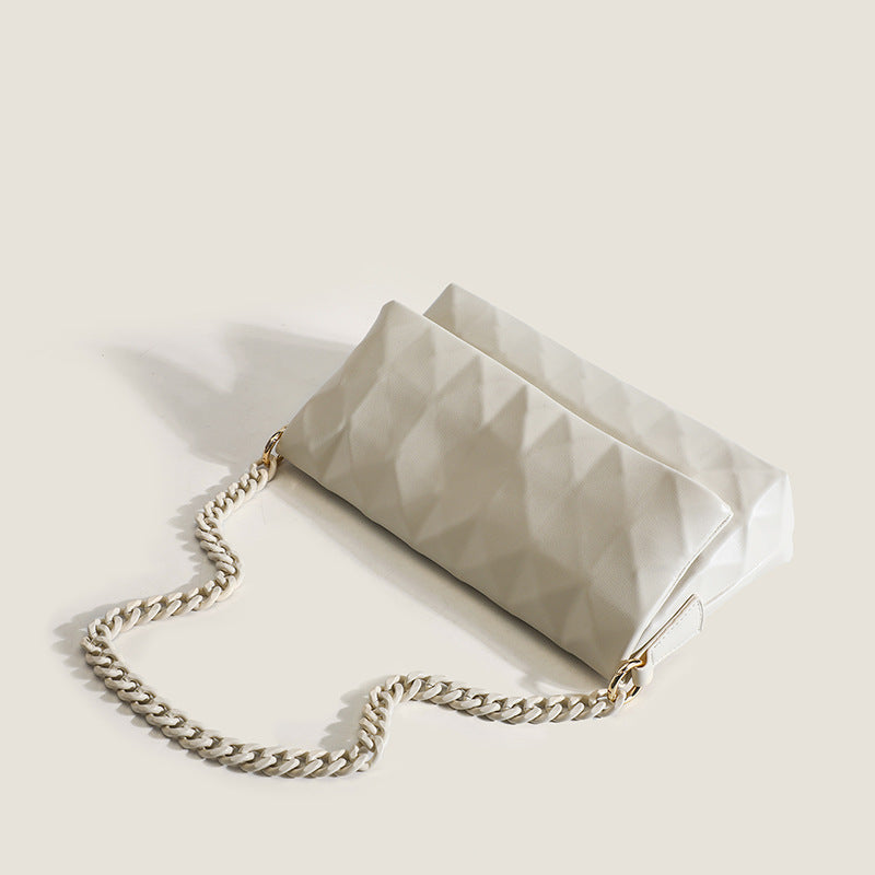Cream white rectangular flap shoulder bag with geometric faceted surface and chunky tone-on-tone chain strap with gold-tone
