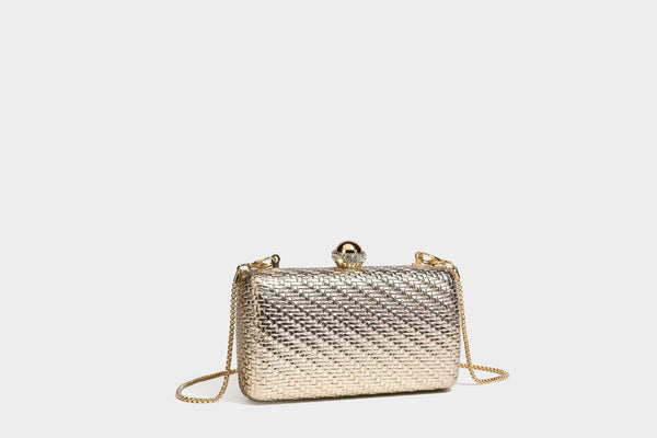 Small structured metallic woven-texture box clutch bag with jeweled kiss-lock dome clasp and slim gold chain strap, detail