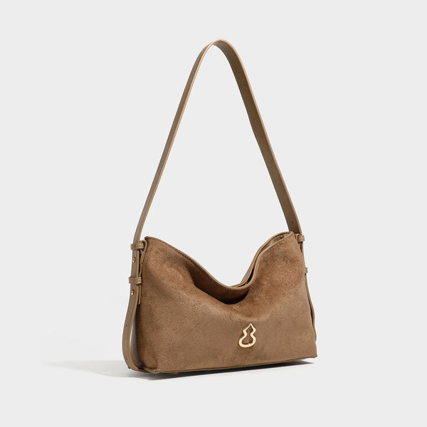 Slouchy suede-finish brown shoulder bag with long single strap and small gold-tone logo emblem on front, detail view 3