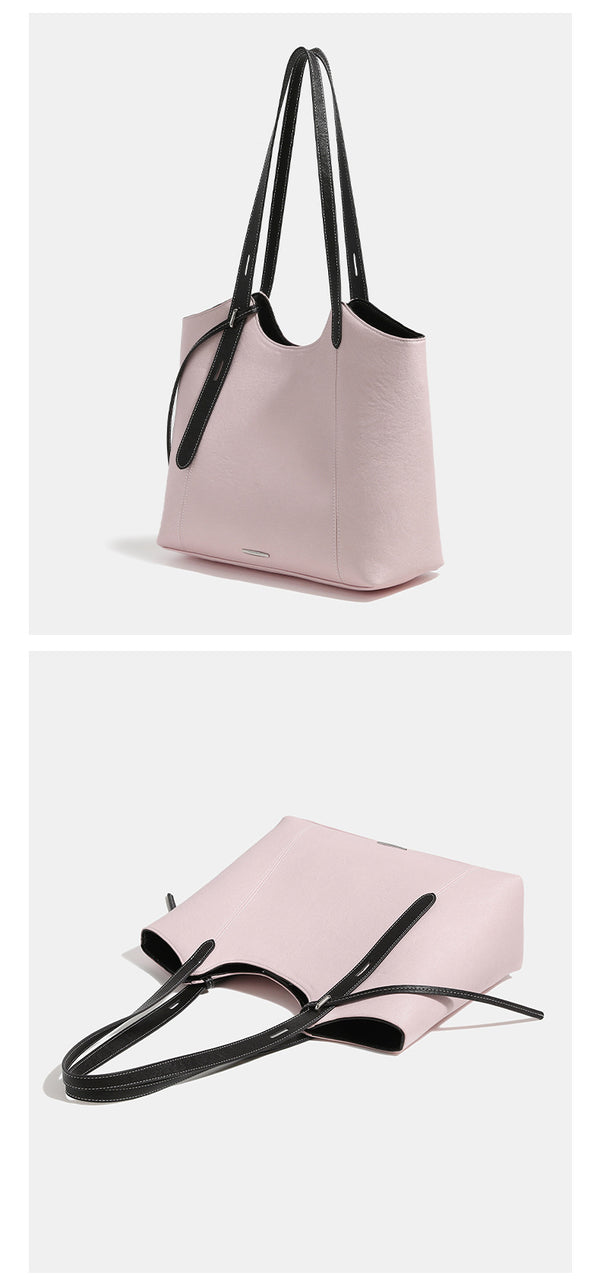 Structured trapezoidal tote bag with smooth leather-look finish, long black contrast shoulder straps, and dangling strap