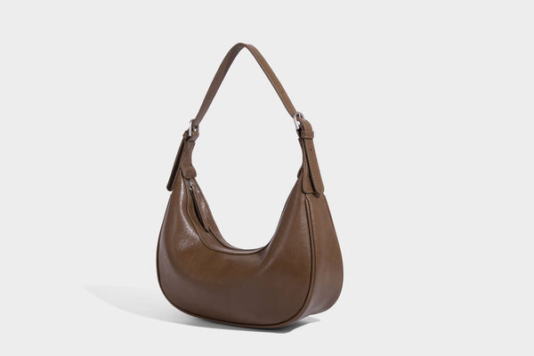 Crescent half-moon shoulder bag in pebbled leather-look finish with adjustable strap and silver-tone hardware, detail view 15