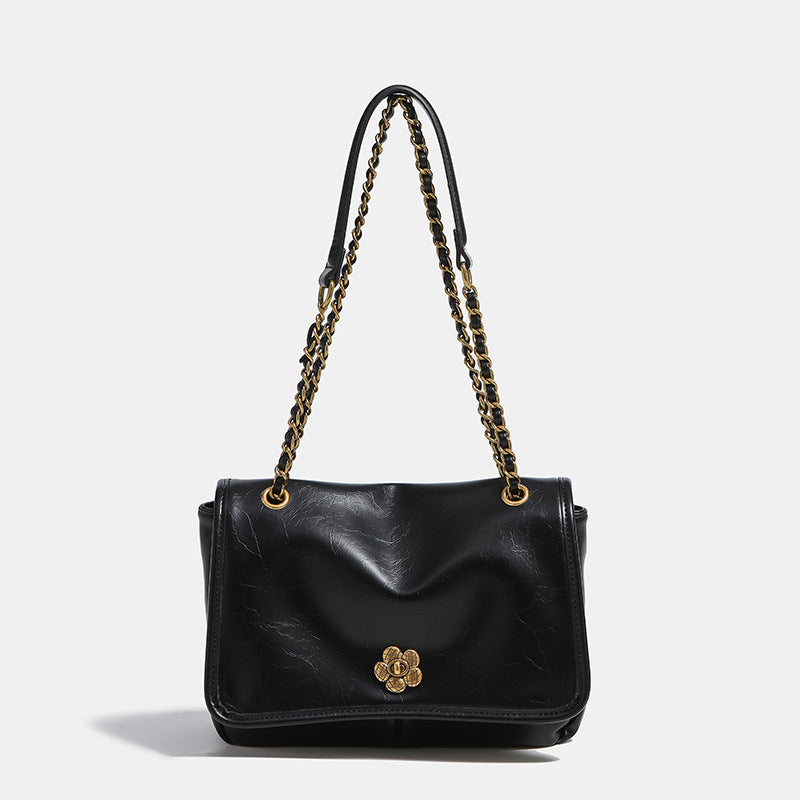 Structured flap shoulder bag with antique gold-tone chain strap and flower turn-lock clasp in crinkled leather-look finish