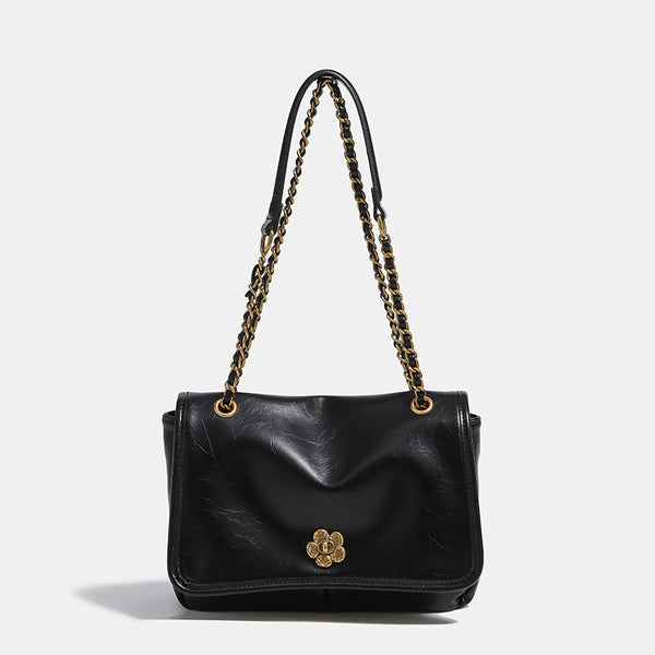 Structured flap shoulder bag with antique gold-tone chain strap and flower turn-lock clasp in crinkled leather-look finish