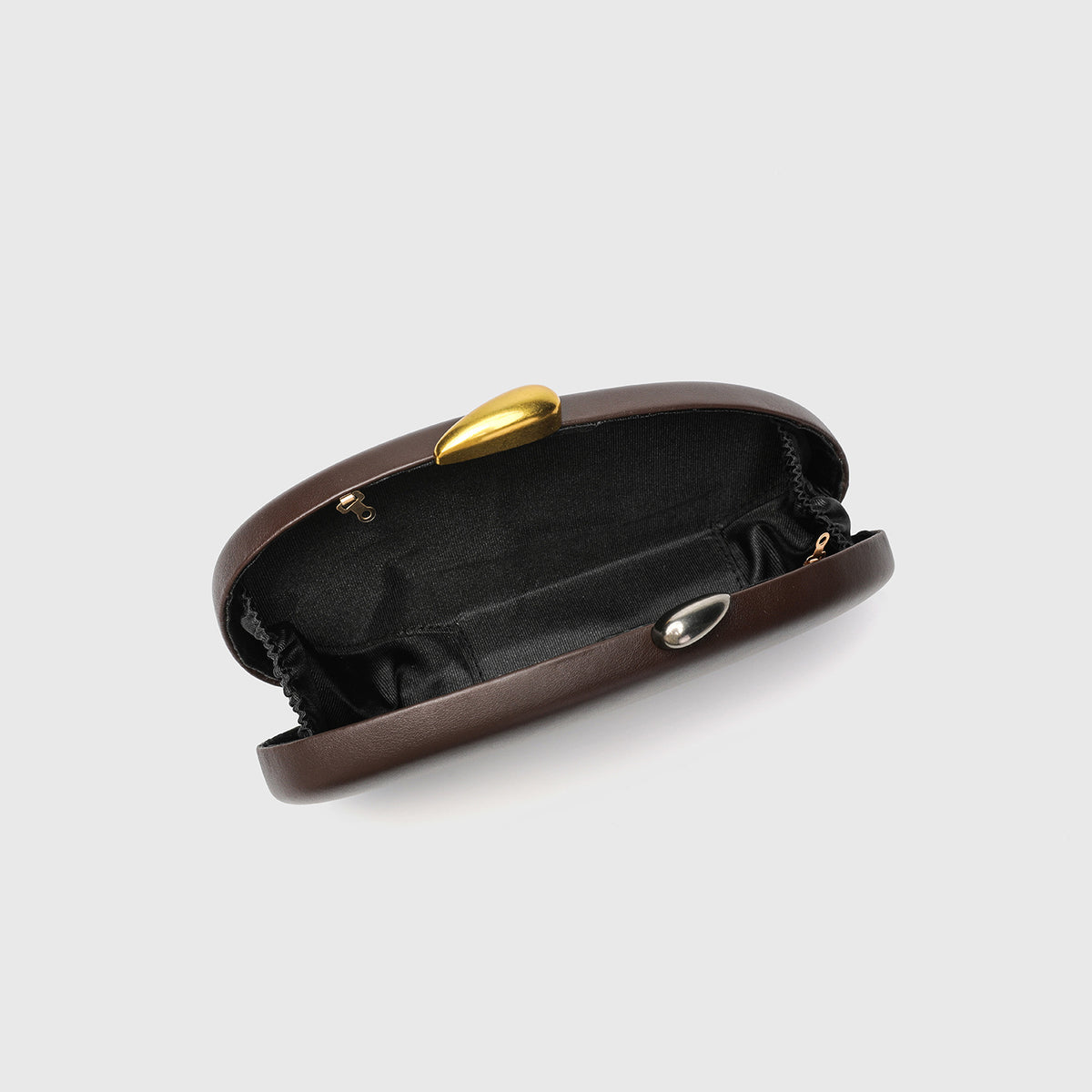 Oval hard-shell crossbody clutch bag with smooth matte leather-look finish and gold-tone snake chain strap, detail view 3