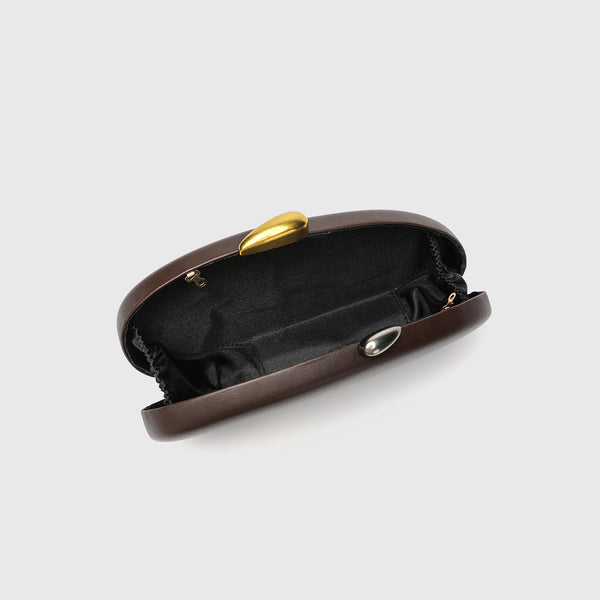Oval hard-shell crossbody clutch bag with smooth matte leather-look finish and gold-tone snake chain strap, detail view 3